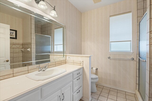 bathroom with tile patterned flooring, vanity, toilet, and a shower with shower door