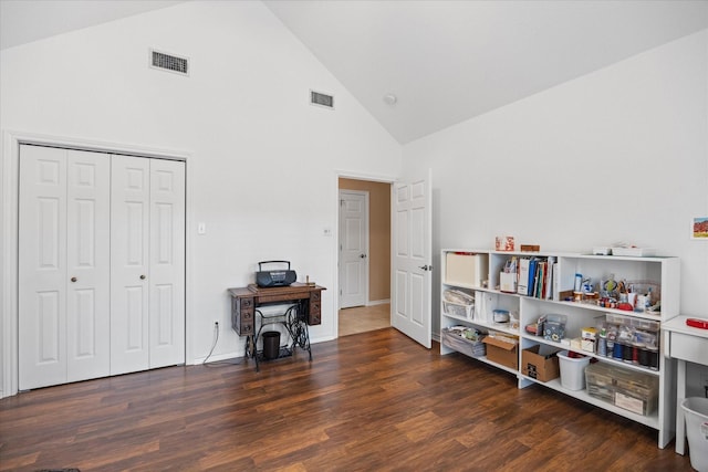 miscellaneous room with high vaulted ceiling and dark wood-type flooring