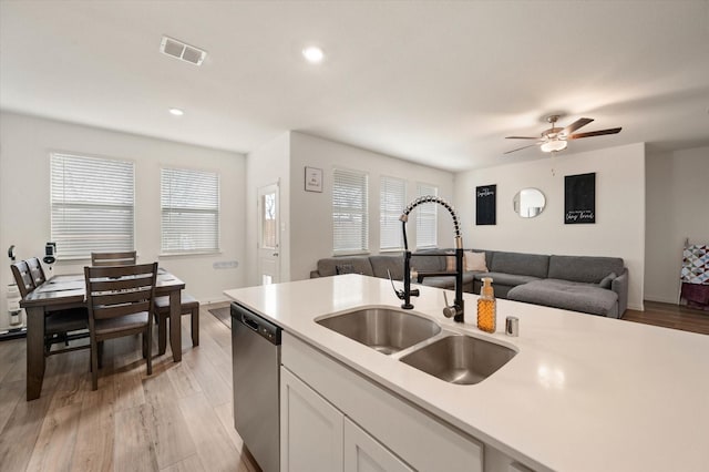 kitchen featuring sink, white cabinetry, dishwasher, ceiling fan, and light hardwood / wood-style floors