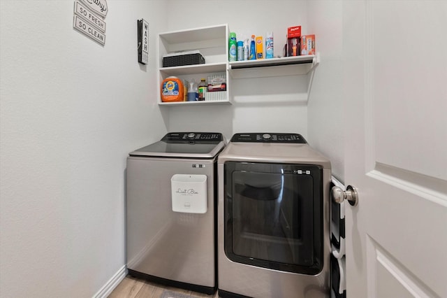 washroom with separate washer and dryer and light hardwood / wood-style flooring