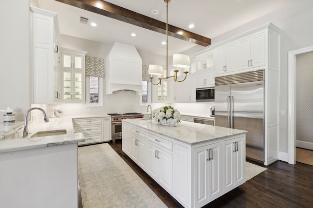 kitchen featuring visible vents, dark wood-type flooring, white cabinets, a sink, and built in appliances