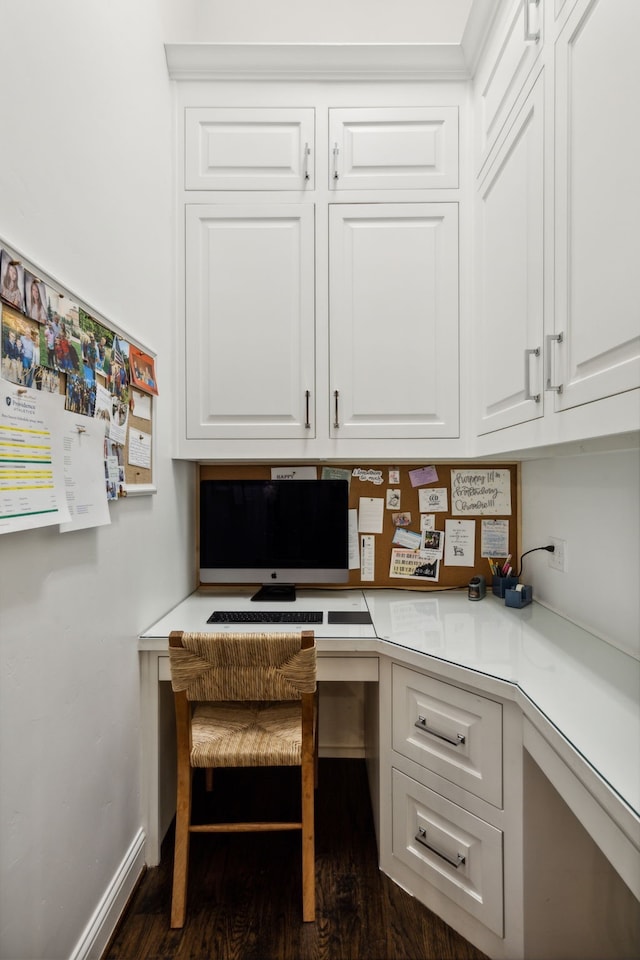 office area with dark wood-style floors, built in study area, and baseboards