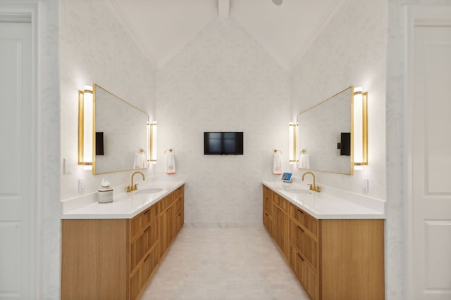 full bathroom with two vanities, vaulted ceiling, and a sink