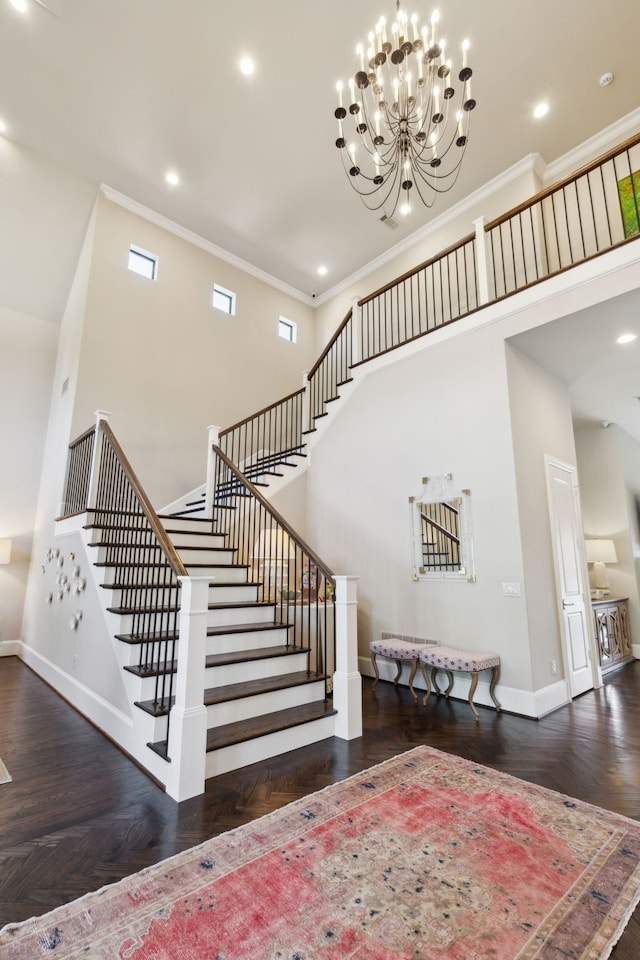 staircase featuring crown molding, a high ceiling, and a notable chandelier