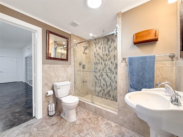 bathroom with toilet, an enclosed shower, and tile walls