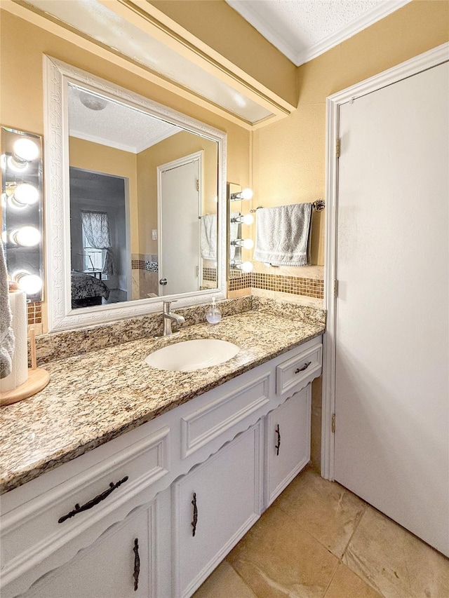 bathroom featuring tile patterned flooring, vanity, ornamental molding, and a textured ceiling