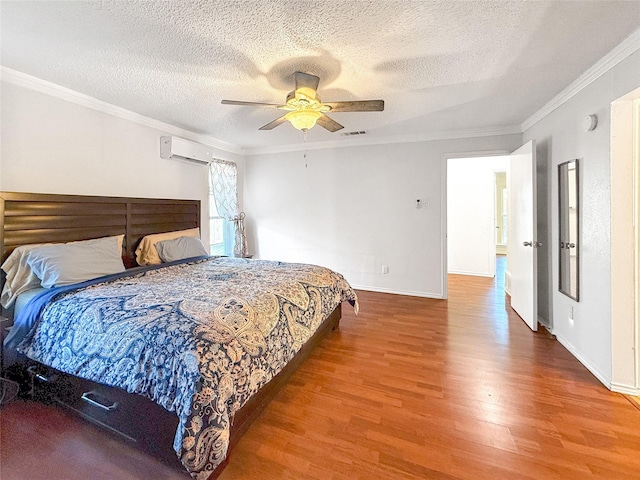 bedroom featuring a textured ceiling, ceiling fan, crown molding, wood-type flooring, and an AC wall unit