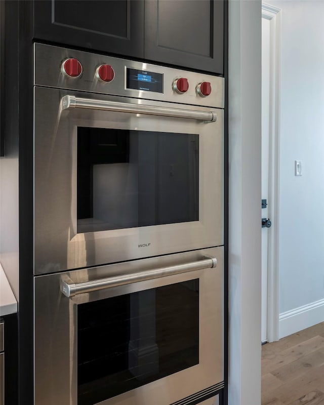 details featuring multiple ovens and light hardwood / wood-style flooring