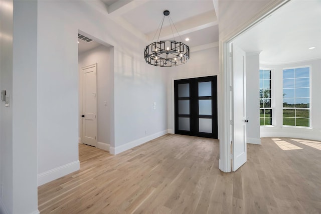 entrance foyer with an inviting chandelier, beam ceiling, and light wood-type flooring