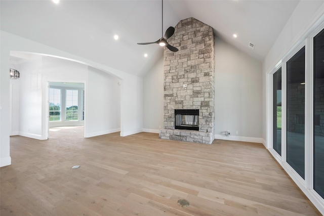 unfurnished living room with ceiling fan, a fireplace, high vaulted ceiling, and light wood-type flooring