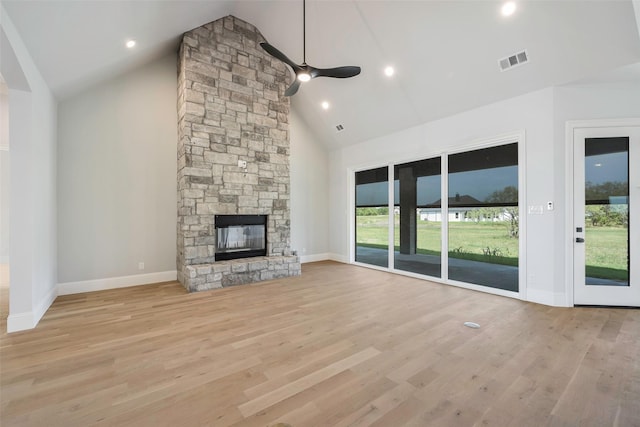 unfurnished living room with high vaulted ceiling, a fireplace, light hardwood / wood-style floors, and ceiling fan