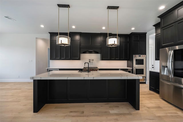 kitchen featuring appliances with stainless steel finishes, a large island, and pendant lighting