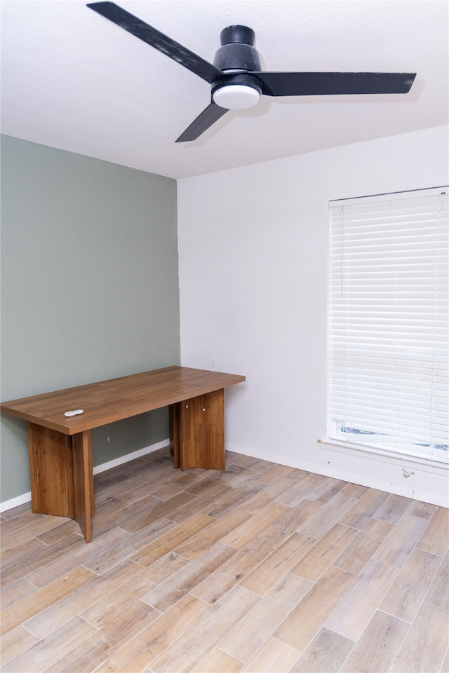 unfurnished office with ceiling fan and light wood-type flooring