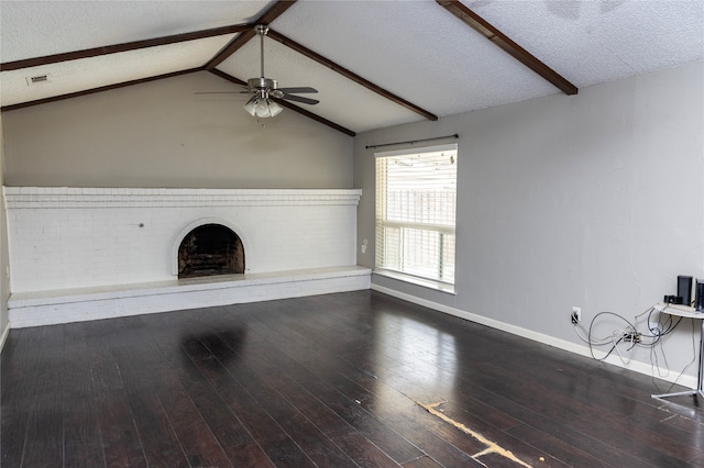 unfurnished living room with a brick fireplace, lofted ceiling with beams, a textured ceiling, and dark wood-type flooring