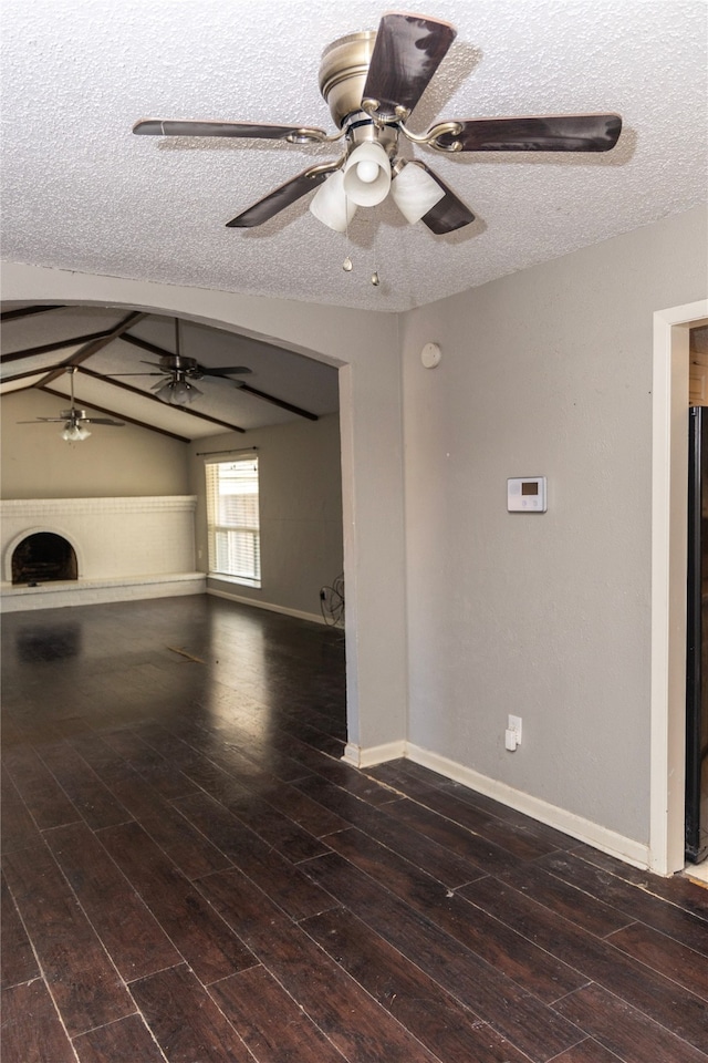 unfurnished living room with a textured ceiling, lofted ceiling, and dark hardwood / wood-style floors