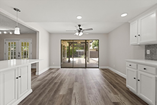 unfurnished dining area featuring ceiling fan, dark hardwood / wood-style flooring, and french doors