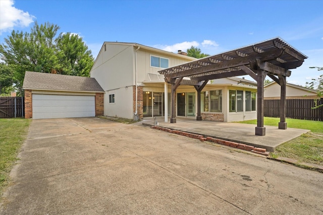 back of property featuring a pergola, a garage, and a sunroom