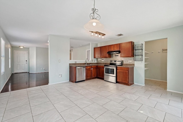 kitchen with light tile patterned floors, sink, hanging light fixtures, stainless steel appliances, and tasteful backsplash