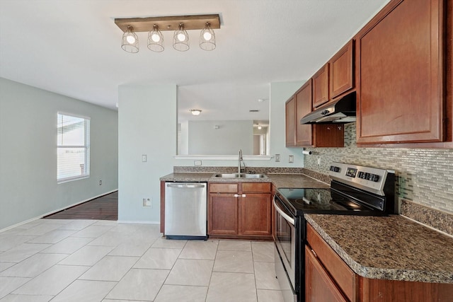 kitchen with tasteful backsplash, appliances with stainless steel finishes, sink, and light tile patterned floors