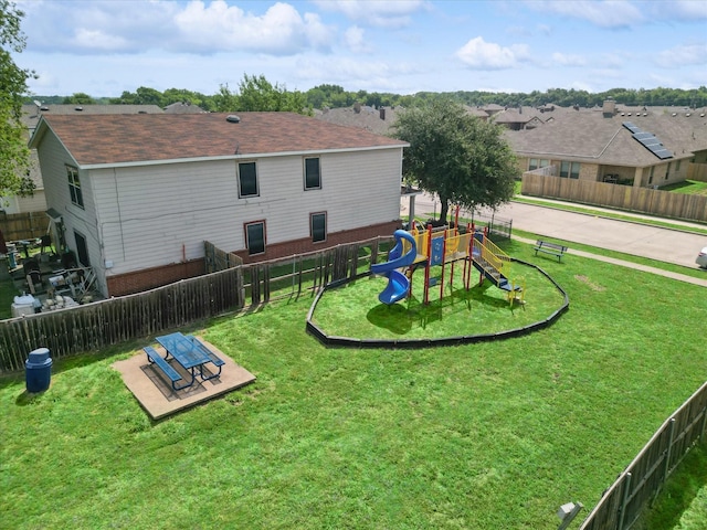 back of house featuring a lawn and a playground