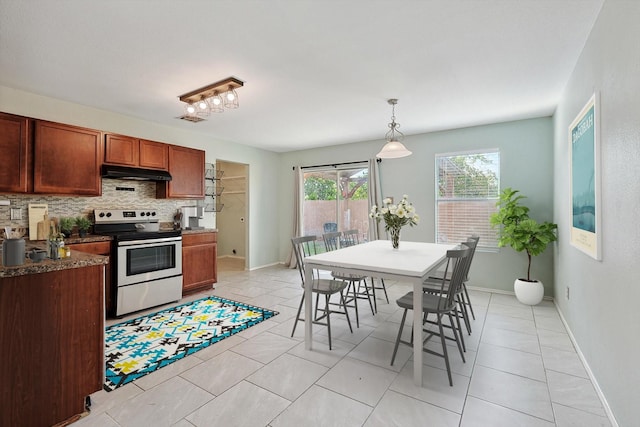 kitchen with light tile patterned floors, decorative light fixtures, stainless steel range with electric cooktop, and decorative backsplash