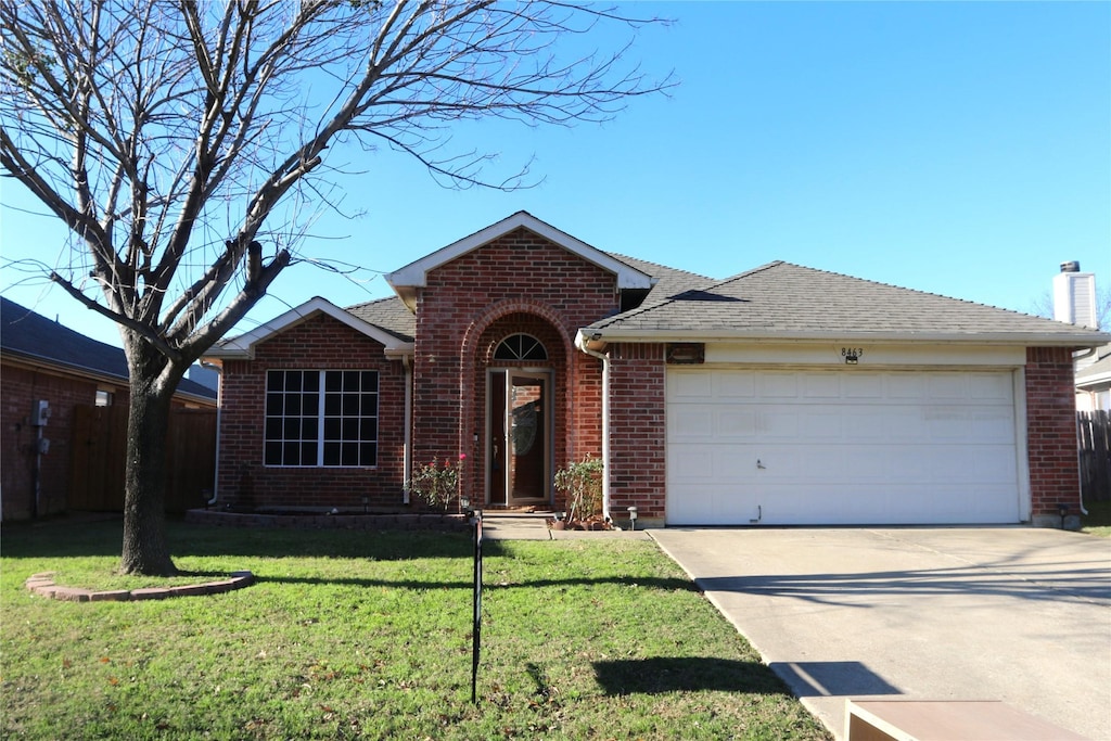 single story home featuring a garage and a front lawn