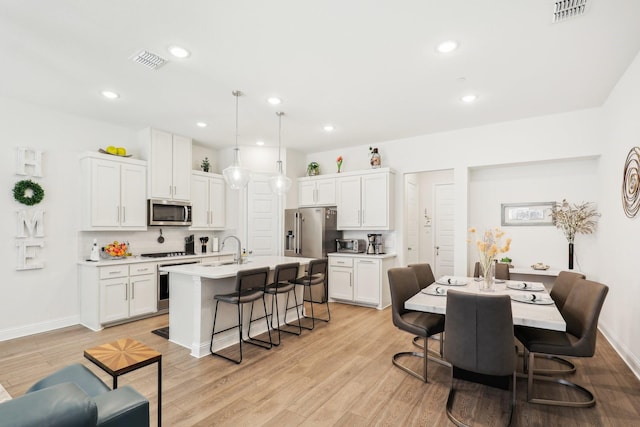 dining area with sink and light hardwood / wood-style flooring