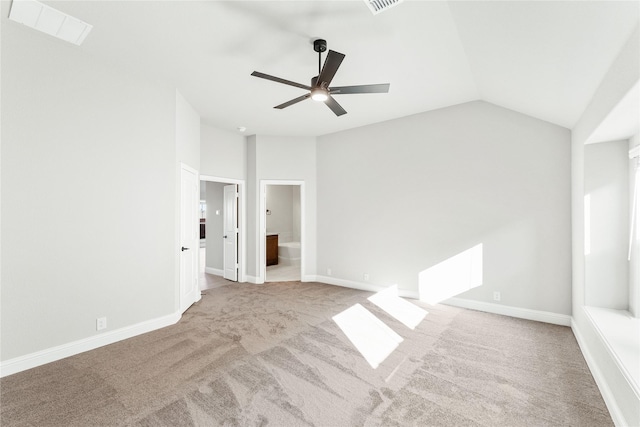 spare room featuring ceiling fan, light carpet, and lofted ceiling