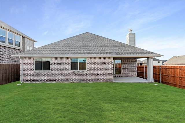 rear view of property featuring a patio area and a yard