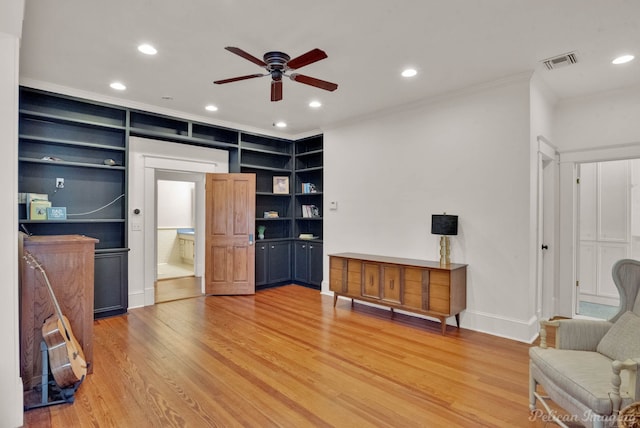 interior space featuring wood-type flooring, built in features, ceiling fan, and crown molding