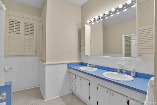 bathroom featuring tile patterned flooring, vanity, and tile walls