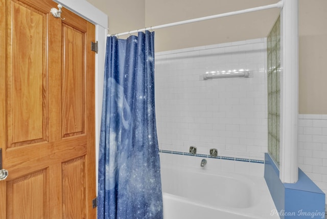 bathroom featuring shower / bath combination with curtain and tile walls