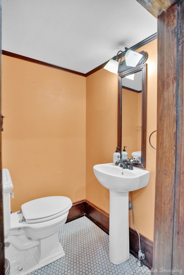 bathroom with ornamental molding, tile patterned flooring, toilet, and baseboards