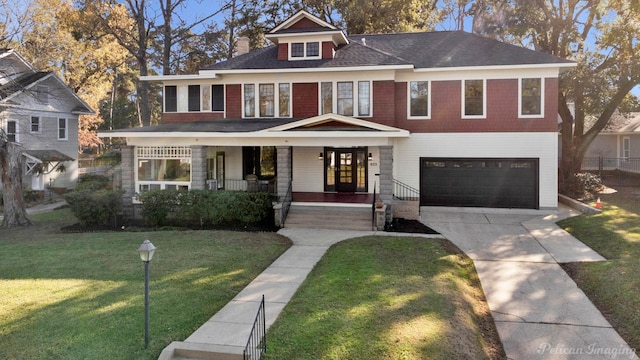 view of front of house featuring a porch, an attached garage, driveway, and a front lawn