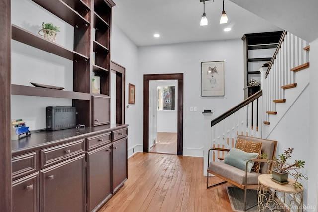 living area featuring baseboards, stairway, light wood-type flooring, and recessed lighting