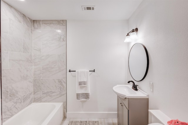 bathroom with vanity and tiled shower / bath combo