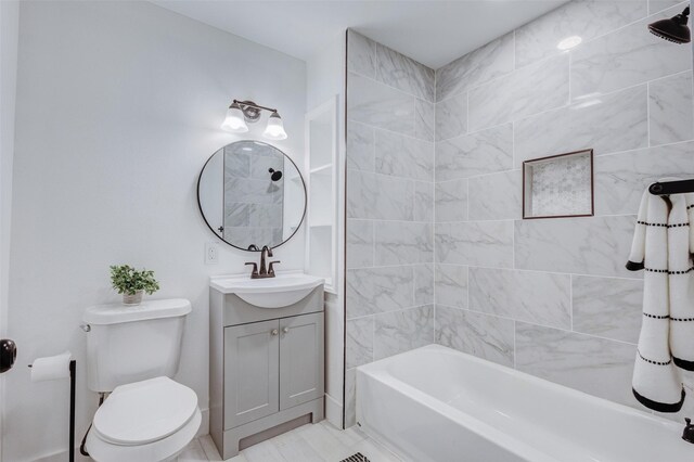 full bathroom with tiled shower / bath, vanity, and toilet