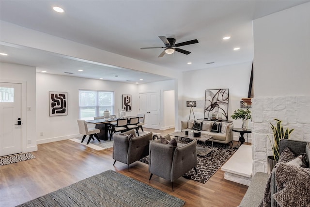 living room with ceiling fan and light hardwood / wood-style flooring