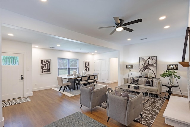 living room featuring wood-type flooring and ceiling fan