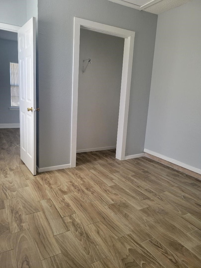 unfurnished bedroom featuring light wood-type flooring and a closet