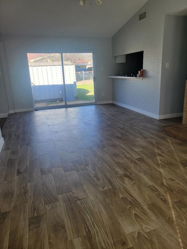 unfurnished living room featuring dark hardwood / wood-style flooring and vaulted ceiling