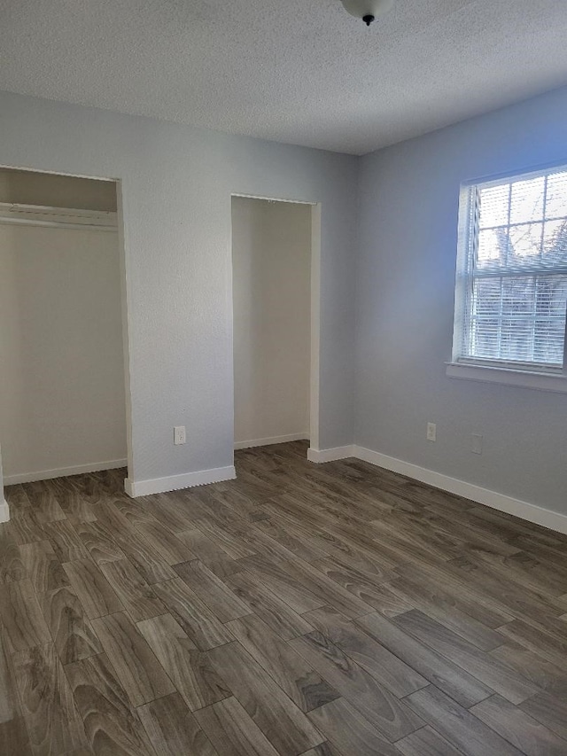 unfurnished bedroom with a closet, dark hardwood / wood-style flooring, and a textured ceiling