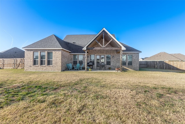 back of property with a patio area and a yard