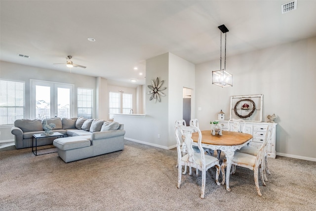 carpeted dining area with ceiling fan