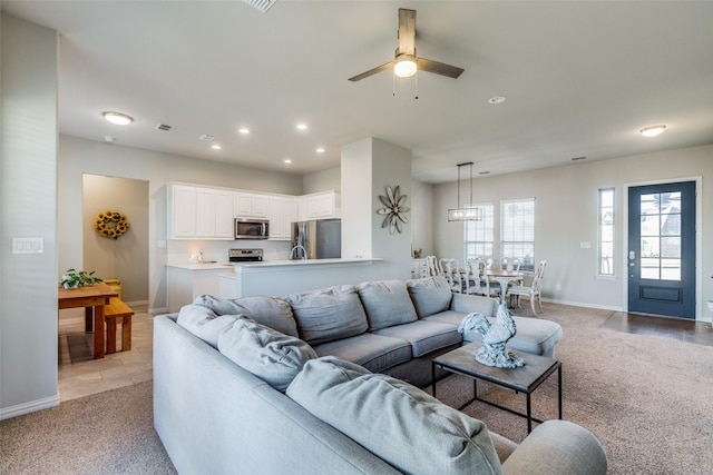 carpeted living room with ceiling fan