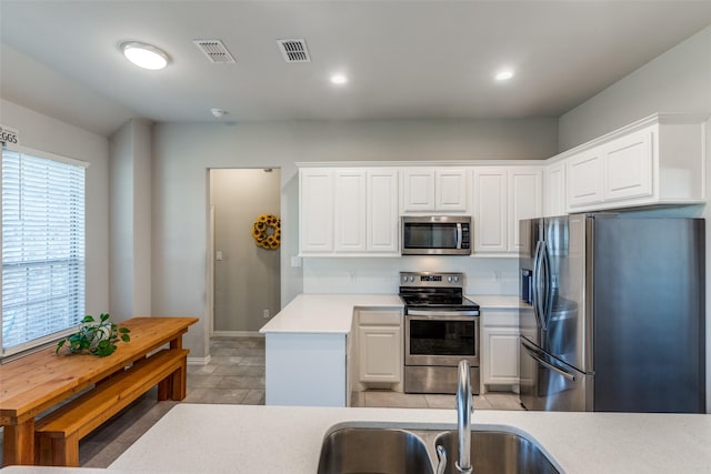 kitchen with appliances with stainless steel finishes, white cabinets, and sink