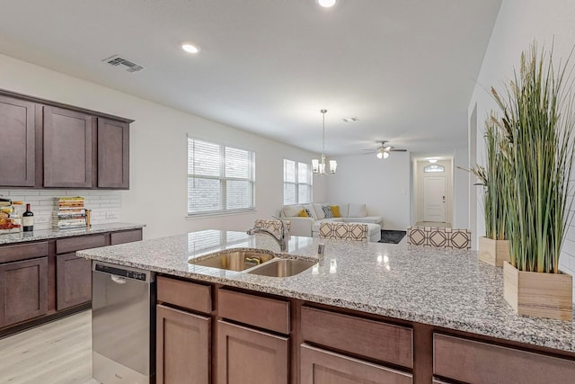 kitchen featuring stainless steel dishwasher, decorative backsplash, sink, light hardwood / wood-style flooring, and light stone countertops