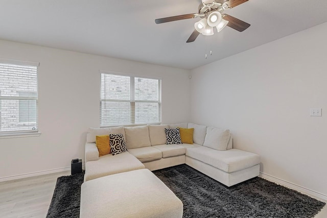 living room featuring light wood-type flooring, ceiling fan, and a wealth of natural light