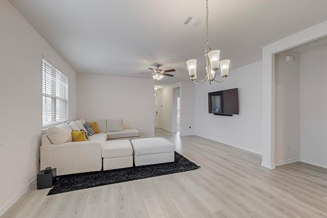 living room with ceiling fan with notable chandelier and light wood-type flooring