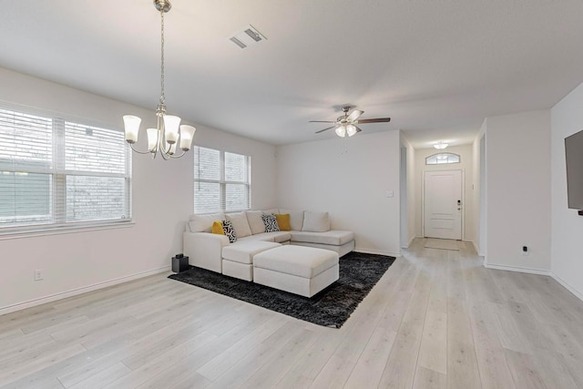 living room with ceiling fan with notable chandelier and light hardwood / wood-style floors